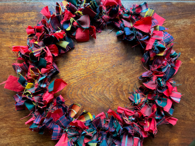 Reduced Tartan Circular Wreath in seasonal colours on a wooden surface