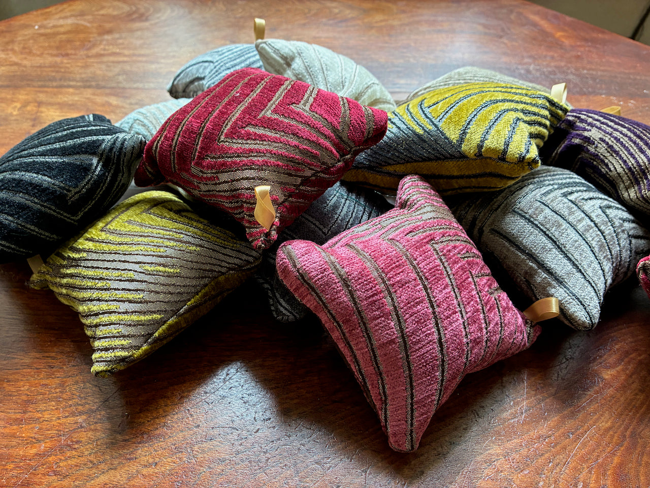 Assorted Art Deco Chenille Pincushions on a wooden surface