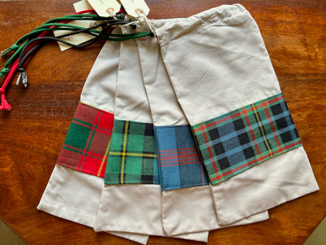 Assorted banded Tartan Drawstring Shoulder Bags on a wooden surface