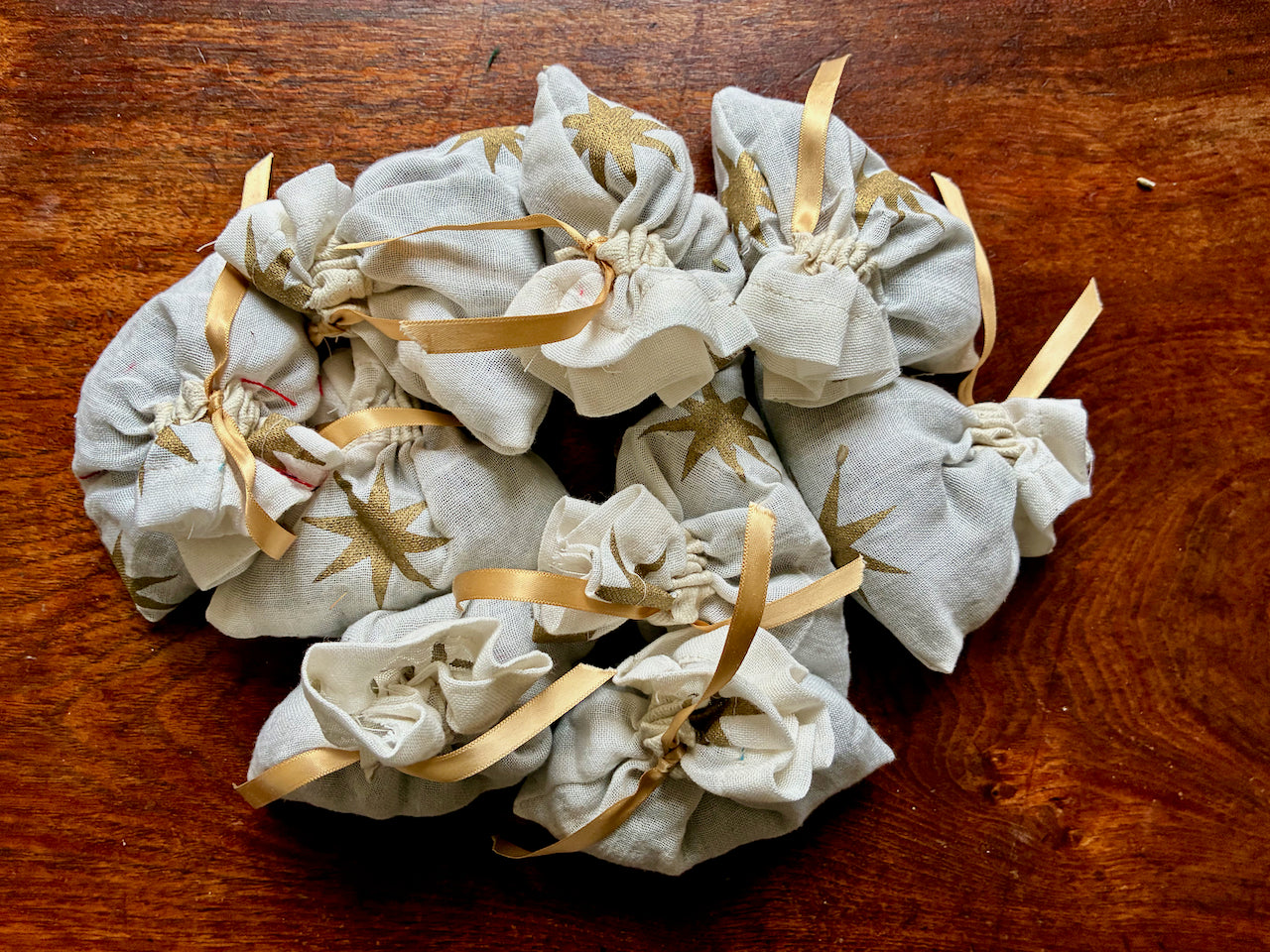 Cream and Gold Lavender Sachets on a wooden surface
