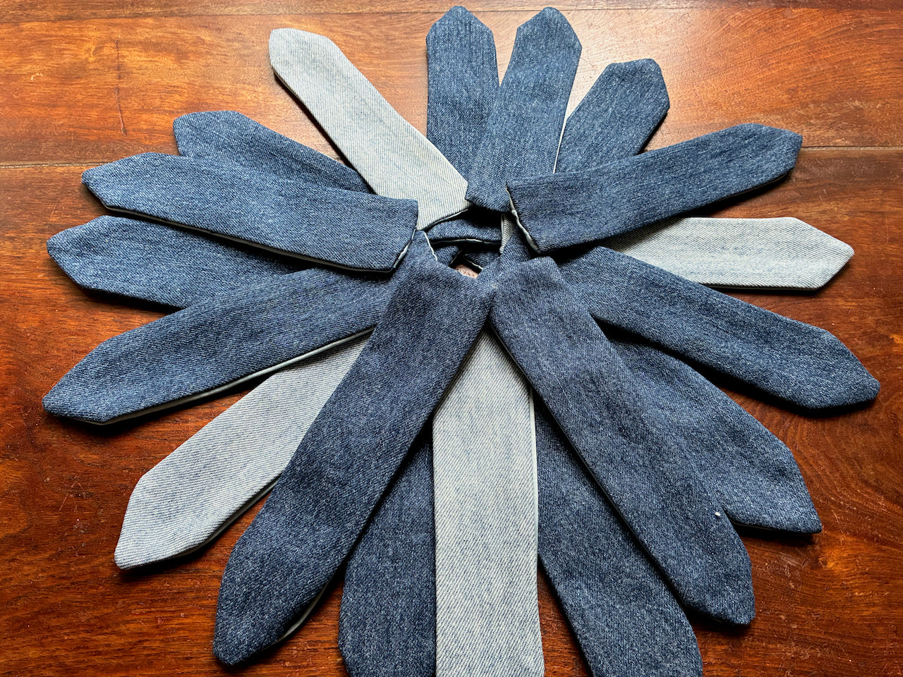 Varied Denim Bookmarks radiaing in a Star deisgn on a wooden surface