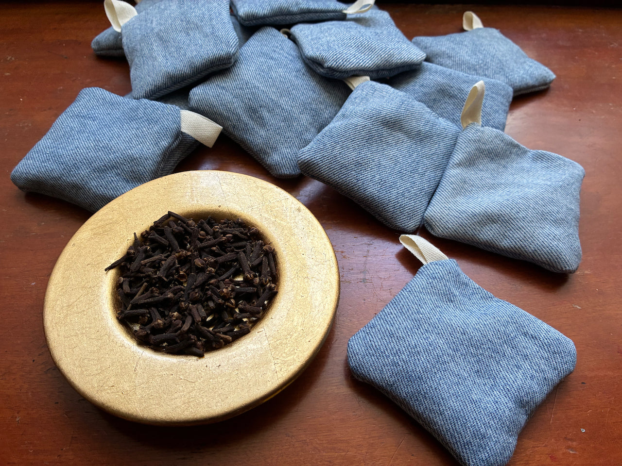 Collection of Blue Denim Clove Sachets and a saucer of Cloves