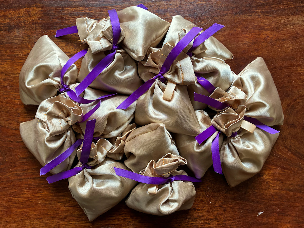 Collection of Gold Silk Lavender Sachets on a wooden surface