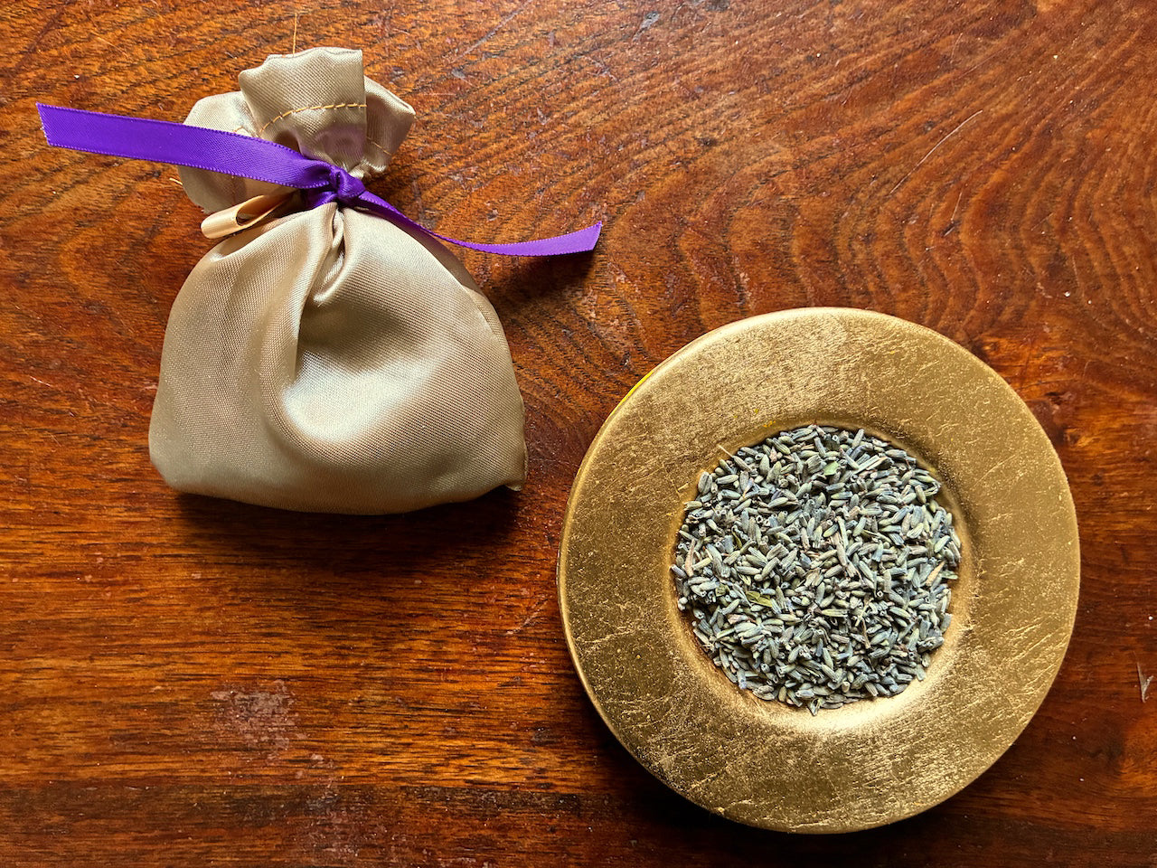 Gold Silk Lavender Sachet with Purple ribbon by a saucer of Dried Lavender