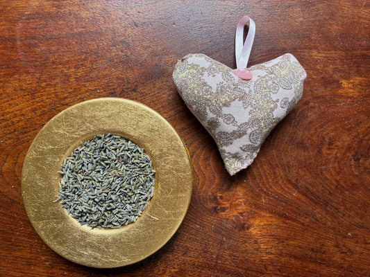 One Grey and Pink Paisley Heart Lavender Sachet by a saucer of Dried Lavender