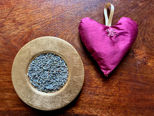 Magenta heart shaped Taffeta Lavender Sacet by a bowl of dried Lavender
