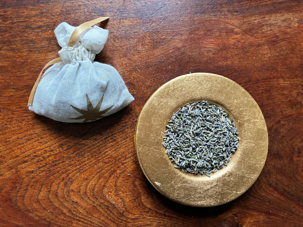 One Cream and Gold Lavender Sachet and a saucer of Dried Lavender