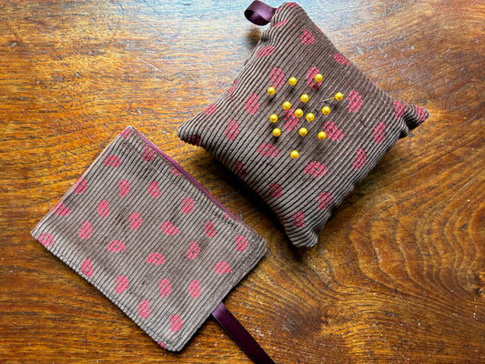 Chestnut and Rose Needle Case and Pincushion Sewing Set with Pins on a wooden surface