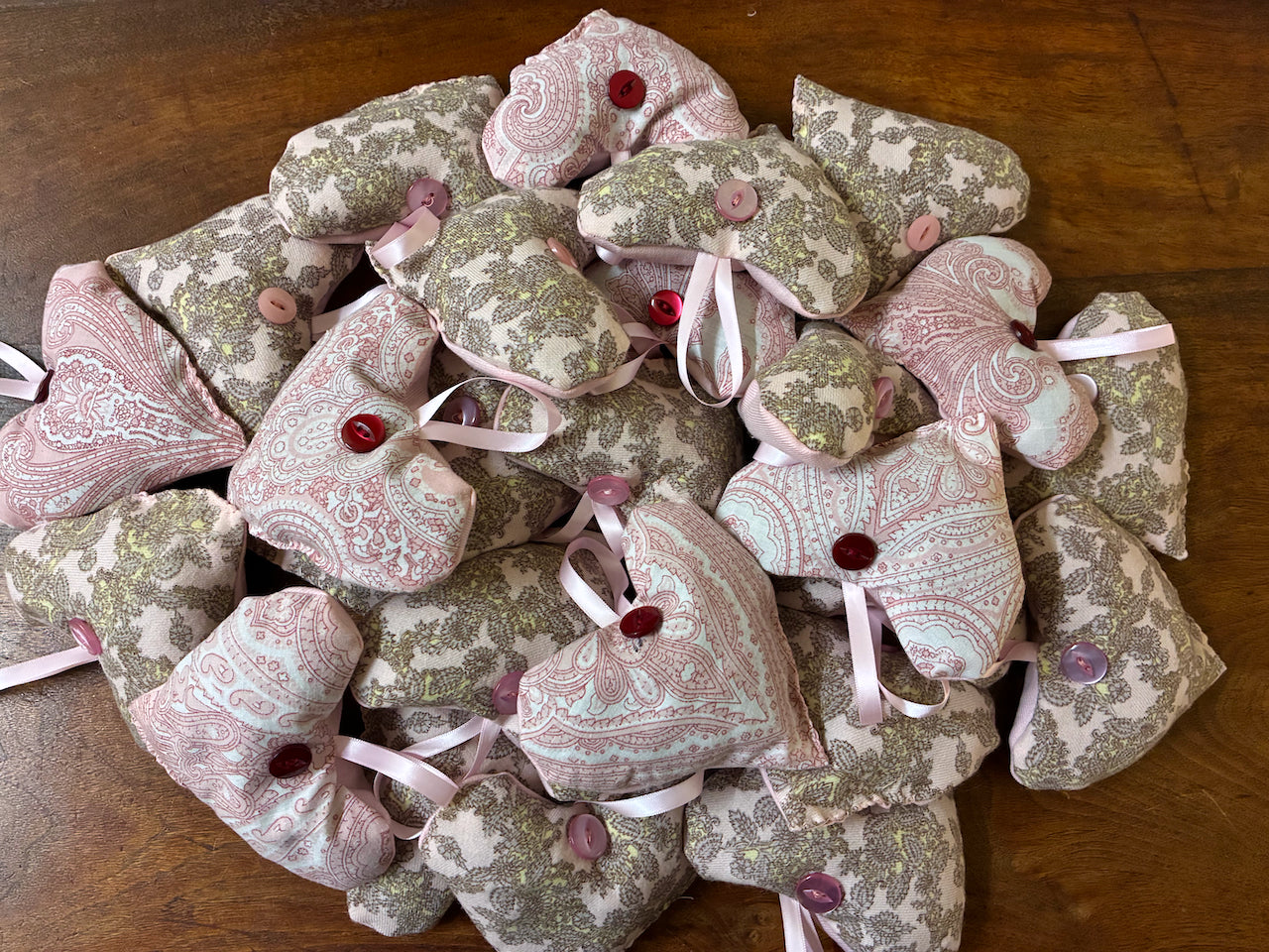 Collection of Pink Paisley Lavender Sachet sets on a wooden surface