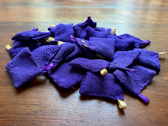 Small Purple Lavender Sachets with Gold and Purple ribbon on a wooden surface