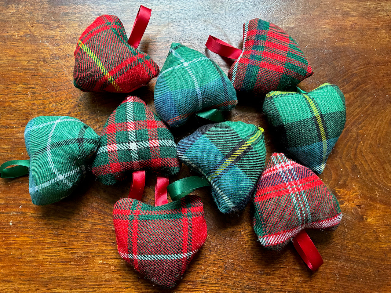 Assorted small decorative Tartan Hearts on a wooden surface