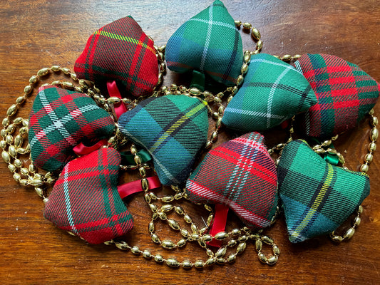 Assorted small Tartan Hearts with a string of Gold Beads on a wooden surface