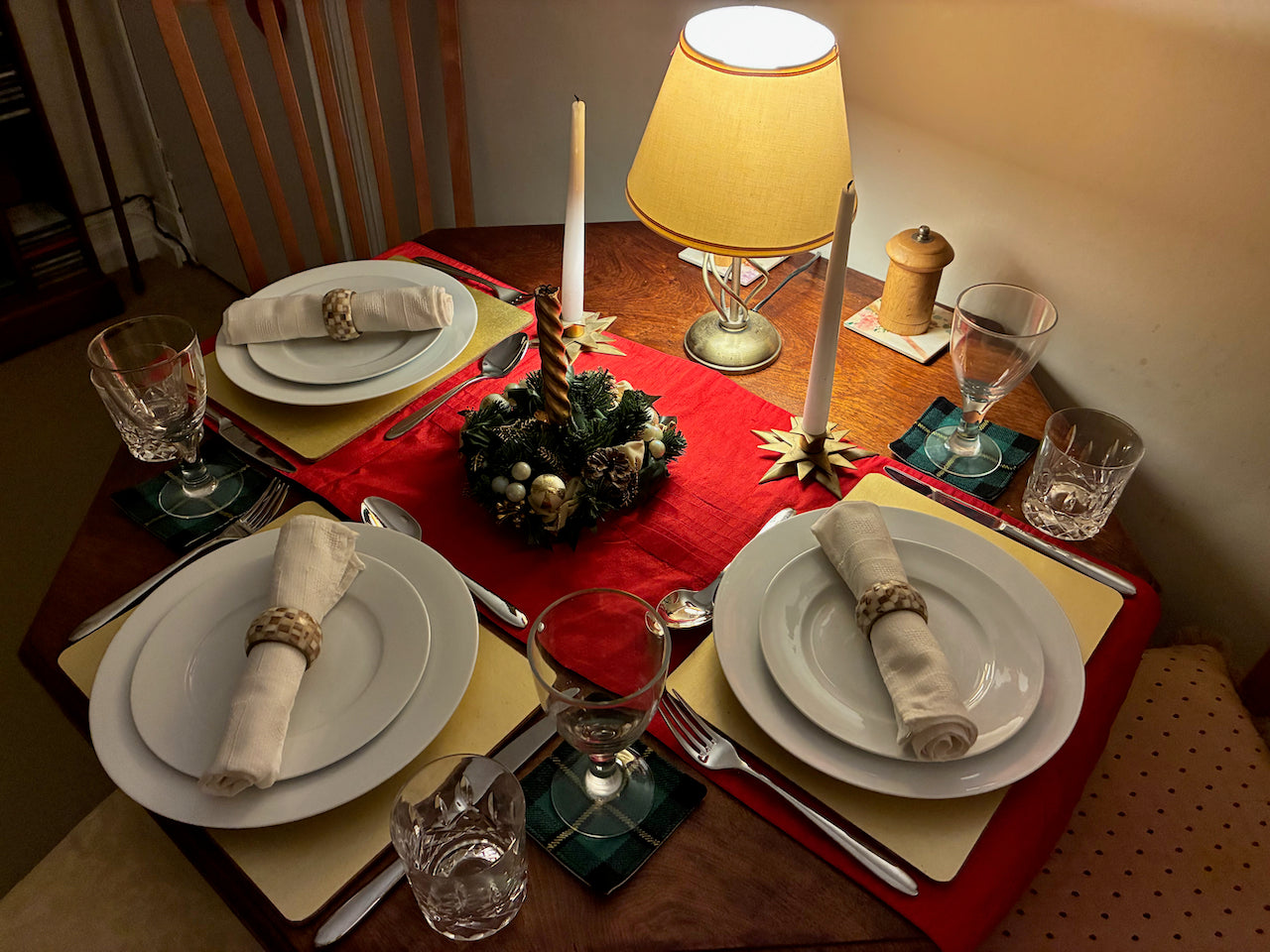 Dining table set for a meal with plates, glasses, cutlery and Tartan Coasters