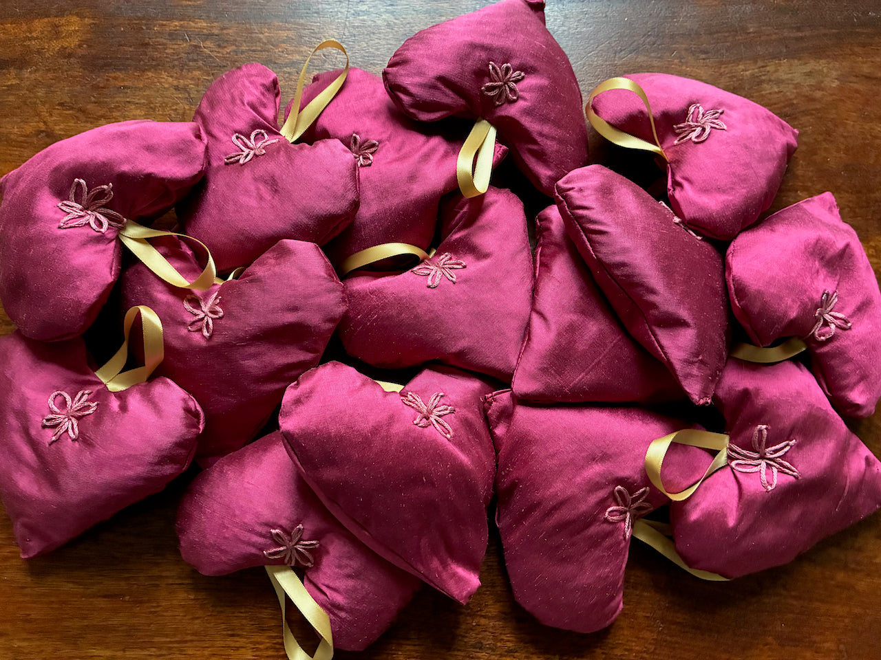 Collection of  Magenta Taffeta Lavender Sachets on a wooden surface
