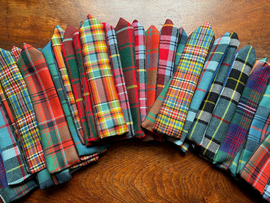 Semi circle of assorted colourful Tartan Bokmarks on a wooden surface