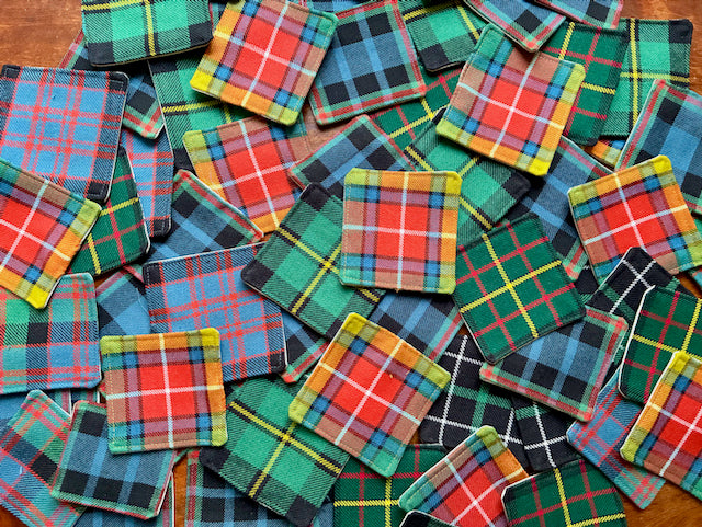 Pile of assorted Tartan Coasters on a wooden table