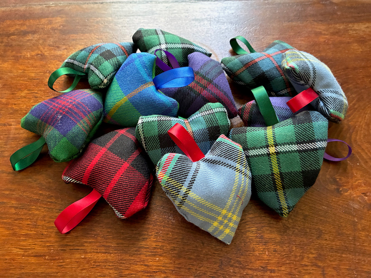 Collection of assorted Tartan Heart Lavender Sachets on a wooden surface