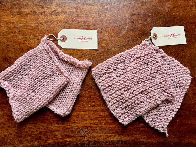 Two Pastel Pink Sets of Knitted Cleaning Cloths on a wooden surface 