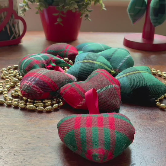 Assorted small decorative Tartan Hearts with a string of Gold beads on a wooden surface