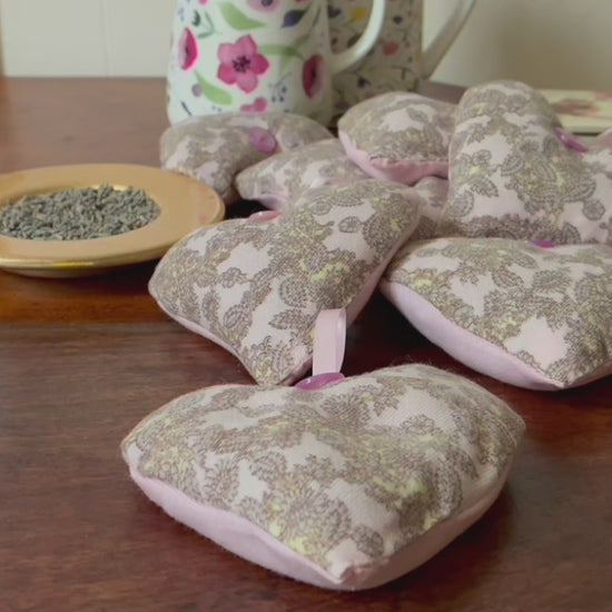 Grey and Pink Paisley Heart Lavender Sachets by a saucer of Dried Lavender 