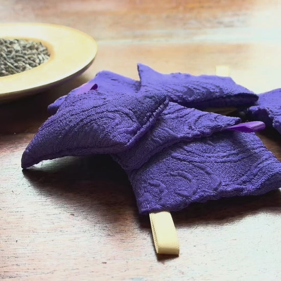 Small Purple Lavender achets and a bowl of Lavender on a wooden table