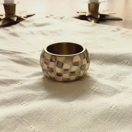 Cream Brocade Napkin being put into a Napkin ring on a wooden table