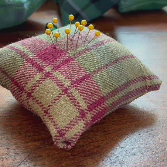 Square Tartan Pincushion with a Satin ribbon and pins in on a wooden surface