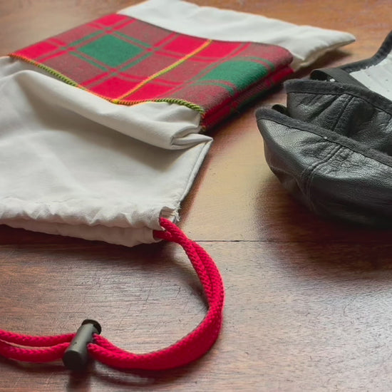 Tartan Drawstring Bag with a set of dance pumps on a wooden surface